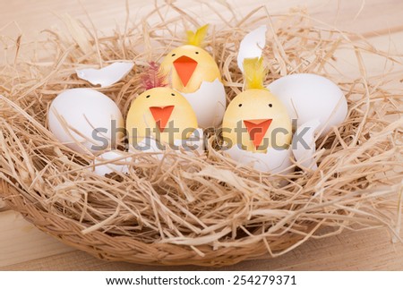 Decorated Easter eggs to look like hatching chicks in a basket - stock 