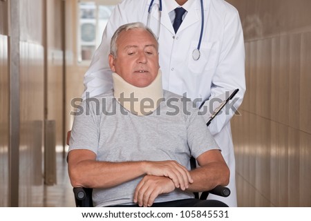 stock-photo-doctor-with-patient-wearing-neck-brace-in-wheelchair-105845531.jpg