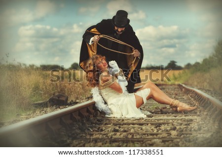 1920 style image of damsel in distress tied up by villain - stock photo
