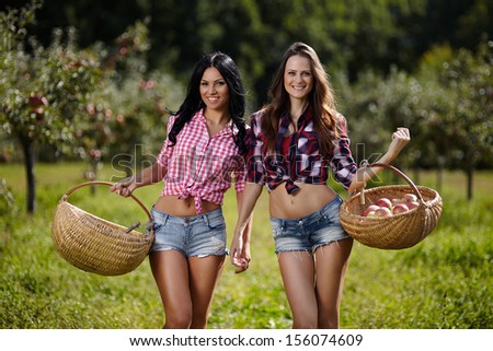 stock-photo-portrait-of-two-attractive-young-women-carrying-baskets-with-apples-in-the-orchard-156074609.jpg