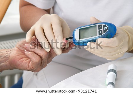 blood glucose meter. the blood sugar value is measured on a finger - stock photo