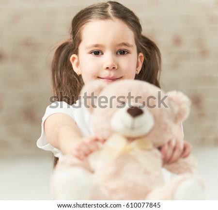 girl hugging huge teddy bear