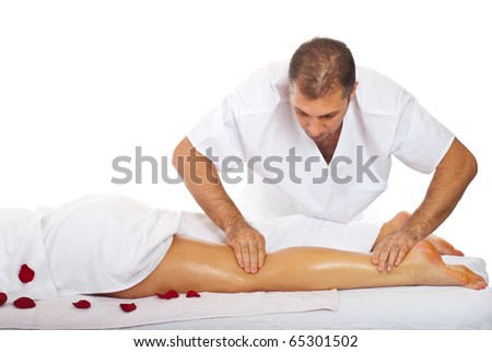 Masseur+Search Masseur giving legs massage to a woman at spa salon - stock photo
