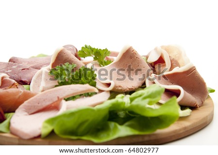Sausage with salad onto plates - stock photo