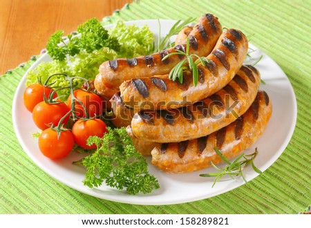 sausages with tomatoes and salad served on a plate - stock photo