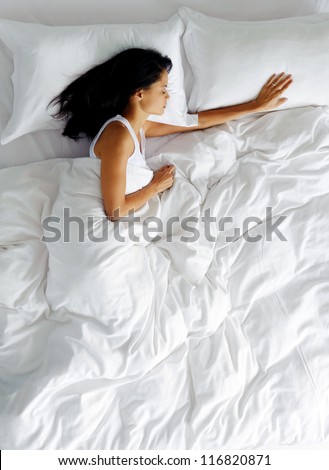 lonely woman in bed missing her partner overhead view of sleeping beauty - stock photo