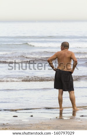 Old Man With Bathing Suit On The Beach - Stock Photo