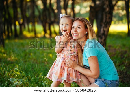 Happy mom and daughter smiling at nature.  - stock photo