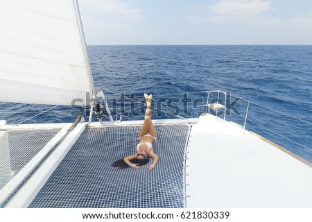 stock photo beautiful young brunette woman in swimsuit is lying on a deck of the catamaran in the sea and 621830339