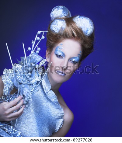 Young woman in creative image with silver artistic makeup and with 