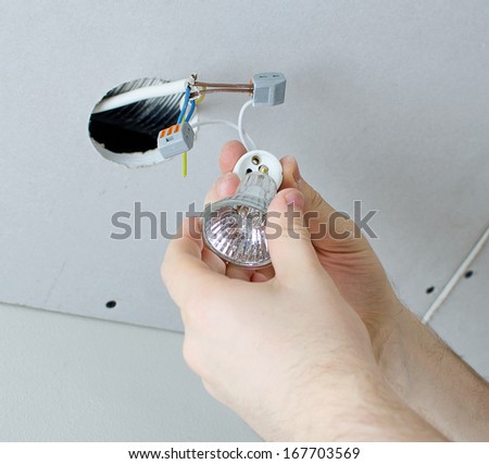 Male hands installing socket for light bulb - stock photo