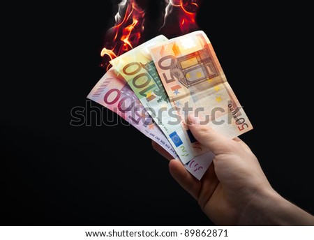 stock-photo-hand-taking-burning-euro-on-a-black-background-89862871.jpg