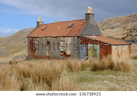 An old derelict building on moorland with tin corrugated roof and shed 