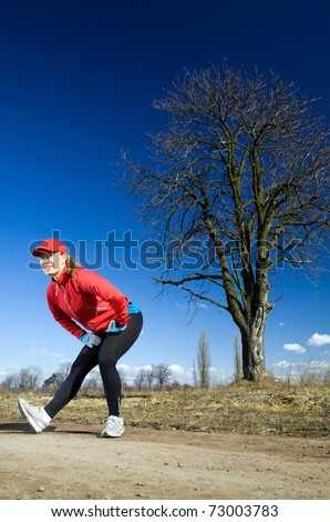 female runner exercising on dirt road early spring. Healthy lifestyle ...