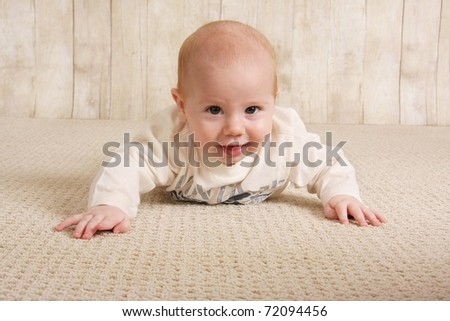Happy five month old baby boy on the floor. - stock photo