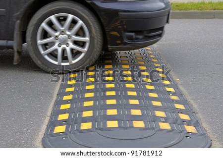 Speed bump on a road when and car - stock photo