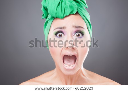Scared woman with green scarf on head with wow expression; open mouth - stock photo