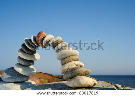 stock-photo-pebbles-curved-as-arch-on-the-seashore-83017819.jpg