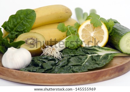  - stock-photo-a-wooden-tray-with-alkaline-diet-vegetables-and-fruits-banana-kiwi-spinach-lemon-cucumber-145555969