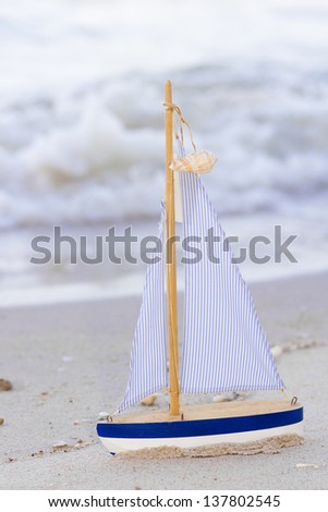 sailboat, blue wooden mini sailboats with sand beach background 