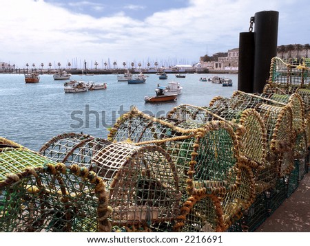 Fishing traps and anchored fishing boats in a port. Cascais, Portugal 
