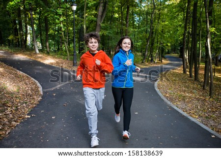 Healthy lifestyle - teenage girl and boy running, jumping outdoor ...