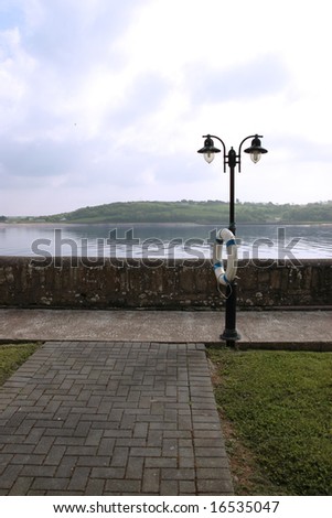  lamp and buoy on a pier in youghal co cork ireland - stock photo