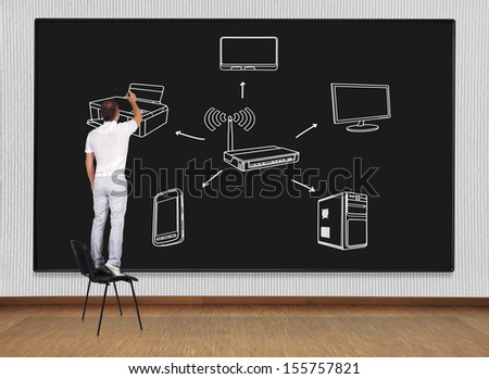 man standing on a chair and drawing computer network - stock photo