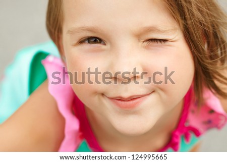 stock-photo-portrait-of-a-cute-girl-winks-closeup-124995665.jpg