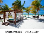 beach beds among palm trees at...