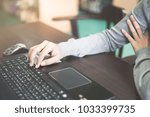 Small photo of Close up business person's hands using computer on wooden table outside the office in weekend. Woman's hands using laptop computer access internet searching information for work outside work place.