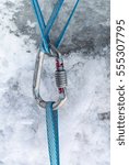 Small photo of Climbing harnesses blue cords are connected together using carabiner, against the background of snow and ice