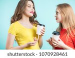 Small photo of Two smiling students having a cup of coffee and fun to talk. Youth, sociability of the concept