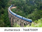 Small photo of Blue passenger train in the Hill Country of Sri Laka. The train is crossing over the Nine Arch Bridge near the touristy town of Ella
