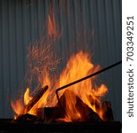 Small photo of Red and orange crackling fire from burning woods in the BBQ outdoors
