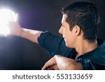 Small photo of young man trying to block the light with his hand against black background