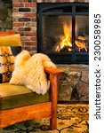 Small photo of Chair by a cozy fireplace with a crackling fire. Gas insert with a glass screen. Style is rustic elegance, lodge, arts and crafts, upscale cabin.