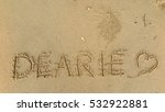 Small photo of Handwriting words "DEARIE" on sand of beach