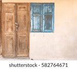Small photo of Classic vintage brown wooden door lock key and closed retro blue window on old concrete wall -concept closed mind.