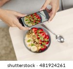 Small photo of Talking picture to her food with a cellphone