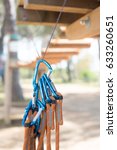 Small photo of Many blue carabiner safety guarantee ready for use, adventure playground path out of focus in background