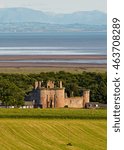 Small photo of Caerlaverock Castle shown within the landscape giving its position next to the Solway Firth in Dumfries and Galloway near the Scottish Border with the English Lake District in the distance.