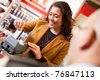 Shop assistant smiling while swiping credit card in supermarket with customer in the foreground - stock photo