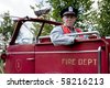Firefighter Sitting In An Retro Firetruck Farmer In Straw Hat And Bib Overalls Holding A Hoe Sitting