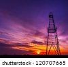 Oil rig structure profiled on warm and beautiful sunset colors - stock photo
