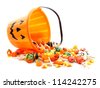 Halloween jack-o-lantern pail with spilling candy over white - stock photo