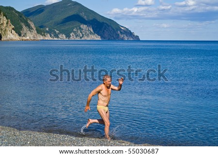 stock-photo-the-man-runs-in-water-along-beach-summer-early-evening-55030687.jpg