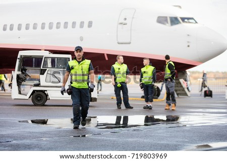 Confident Worker In Walking While Colleagues Standing On Wet Run