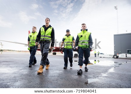 Low Angle View Of Workers Walking On Runway