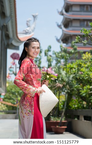 Vertical portrait of an attractive Asian woman in temple smiling and looking at camera